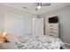 Bedroom with carpet, ceiling fan, bed with floral comforter, wooden headboard, dresser, and closet at 4559 Dover Straight St, Las Vegas, NV 89115