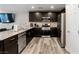 Modern kitchen with dark cabinetry, stainless steel appliances, granite counters, and wood-look floors at 4559 Dover Straight St, Las Vegas, NV 89115