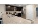 Modern kitchen with granite countertops, stainless steel appliances and dark wood cabinets at 4559 Dover Straight St, Las Vegas, NV 89115