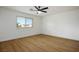 Bright bedroom featuring light wood flooring, a ceiling fan, and a window offering street views at 4797 E Imperial Ave, Las Vegas, NV 89104