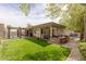 Expansive backyard features a lush lawn, outdoor kitchen, covered patio, and pergola leading to a serene pool area at 48 Panorama Crest Ave, Las Vegas, NV 89135