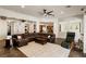 Open-concept living room with dark brown leather sectional, ceiling fan, and tile flooring at 48 Panorama Crest Ave, Las Vegas, NV 89135