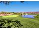 Picturesque golf course view with a pond and fountain, surrounded by lush green grass and distant mountain views at 499 Eagle Vista Dr, Henderson, NV 89012