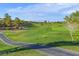 Scenic view of the golf course with rolling green fairways, a pond, and mountains in the background at 499 Eagle Vista Dr, Henderson, NV 89012