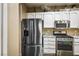 This kitchen includes stainless steel appliances, white cabinets, and granite countertops at 499 Eagle Vista Dr, Henderson, NV 89012