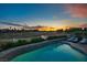 A beautiful swimming pool with lounge chairs overlooking a lush green golf course at sunset at 499 Eagle Vista Dr, Henderson, NV 89012