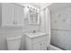 Clean bathroom featuring a single sink vanity, matching white cabinets, and a shower with decorative tile surround at 5101 Churchill Ave, Las Vegas, NV 89107