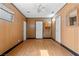 Living room with wood-look floors, wood-paneled walls, and multiple doors for easy access at 5101 Churchill Ave, Las Vegas, NV 89107
