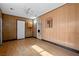 Spacious living room features wood-look floors, wood-paneled walls, and access to additional rooms at 5101 Churchill Ave, Las Vegas, NV 89107