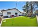 Spacious backyard with artificial grass, a playset, and outdoor seating at 5876 Tippin Dr, Las Vegas, NV 89130