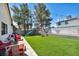 Artificial grass backyard with a playset, mature trees, and string lights at 5876 Tippin Dr, Las Vegas, NV 89130