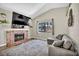 Living room showcasing a brick fireplace, flat screen TV, and backyard view at 5876 Tippin Dr, Las Vegas, NV 89130