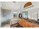 Bathroom showcasing a double vanity, bathtub, shower with glass enclosure, and large mirror, plus backyard views at 59 Desert Dawn Ln, Henderson, NV 89074