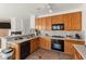 Well-equipped kitchen featuring wood cabinets, black appliances, and ample counter space at 59 Desert Dawn Ln, Henderson, NV 89074