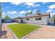 Spacious backyard featuring an artificial lawn, gravel landscaping, shed and covered patio with bright blue skies at 6229 Cromwell Ave, Las Vegas, NV 89107