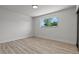 Bright bedroom featuring laminated floors, base molding, neutral colored walls, and a window with backyard view at 6229 Cromwell Ave, Las Vegas, NV 89107
