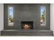 Close-up of the grand brick fireplace with side windows that bring natural light into the home at 6229 Cromwell Ave, Las Vegas, NV 89107