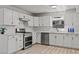 Modern kitchen with stainless steel appliances, white cabinetry, and a stylish backsplash at 6229 Cromwell Ave, Las Vegas, NV 89107
