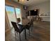 Dining area with sleek table and chairs, sliding glass door, and wood flooring throughout at 6700 Oak Valley Dr, Las Vegas, NV 89103