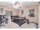 Neutral-toned bedroom with ceiling fan, carpet, and a window allowing natural light at 6954 Jacksboro Ct, North Las Vegas, NV 89084