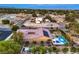 Overhead view of a house with solar panels, a pool, and outdoor seating, enveloped by greenery in a quiet neighborhood setting at 7111 Bath Dr, Las Vegas, NV 89131