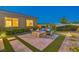 Backyard oasis featuring a stone fire pit area, ample seating, and manicured landscaping at 7111 Bath Dr, Las Vegas, NV 89131