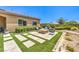 Backyard with fire pit, landscaped area, and well-maintained artificial turf at 7111 Bath Dr, Las Vegas, NV 89131
