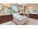 Luxurious bathroom with a soaking tub, dual vanities, and a large window offering a view at 7111 Bath Dr, Las Vegas, NV 89131