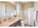 Well-lit bathroom featuring a large mirror, white bathtub with shower, and dark wood vanity at 7111 Bath Dr, Las Vegas, NV 89131