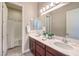 Well-lit bathroom with double sinks, a large mirror, and a separate shower and bathtub at 7111 Bath Dr, Las Vegas, NV 89131