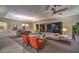 Comfortable living area with orange accent chairs, sliding glass doors to the outside and sleek ceiling fan at 7111 Bath Dr, Las Vegas, NV 89131