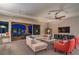Inviting living room with a plush sectional sofa, a modern entertainment center, and seamless outdoor access at 7111 Bath Dr, Las Vegas, NV 89131