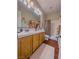 Bright bathroom featuring double sinks, wood cabinets, and a shower-tub combination at 7225 Millerbird St, North Las Vegas, NV 89084