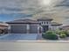 A modern home with a three car garage, desert landscaping, and appealing architectural details at 7225 Millerbird St, North Las Vegas, NV 89084