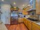 Bright kitchen with wood cabinets, stainless steel appliances, granite counters, and wood flooring at 7225 Millerbird St, North Las Vegas, NV 89084