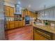 Bright kitchen with wood cabinets, stainless steel appliances, granite counters, and wood flooring at 7225 Millerbird St, North Las Vegas, NV 89084