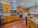 Bright kitchen with wood cabinets, stainless steel appliances, granite counters, and wood flooring at 7225 Millerbird St, North Las Vegas, NV 89084