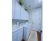 Clean laundry room with white cabinets, washer, dryer, and utility sink at 7225 Millerbird St, North Las Vegas, NV 89084