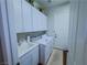 Clean laundry room with white cabinets, washer, dryer, and utility sink at 7225 Millerbird St, North Las Vegas, NV 89084