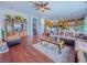 Spacious living area boasting wood floors, a ceiling fan, and an open layout to the kitchen at 7225 Millerbird St, North Las Vegas, NV 89084