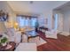 Bright and airy living room featuring hardwood floors, comfortable white sofas, and sheer curtains at 7225 Millerbird St, North Las Vegas, NV 89084