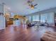 Well-lit living room showing wood floors, open layout to the kitchen, and ceiling fan at 7225 Millerbird St, North Las Vegas, NV 89084