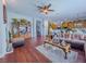 Open-concept living room featuring wood floors, a ceiling fan, and seamless flow to the kitchen at 7225 Millerbird St, North Las Vegas, NV 89084
