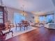Open-concept living and dining area with elegant chandelier and hardwood flooring at 7225 Millerbird St, North Las Vegas, NV 89084