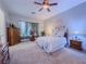 Cozy main bedroom featuring plush carpeting, ceiling fan, and abundant natural light at 7225 Millerbird St, North Las Vegas, NV 89084