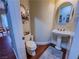 Small powder room with pedestal sink, toilet, and decorations at 7225 Millerbird St, North Las Vegas, NV 89084