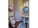Small powder room with pedestal sink, oval mirror, and adjacent toilet at 7225 Millerbird St, North Las Vegas, NV 89084