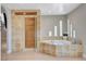 Luxurious bathroom featuring a standalone shower, soaking tub, and earth-toned tile accents at 7761 Cowboy Trl, Las Vegas, NV 89131