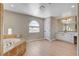 Bright bathroom featuring a soaking tub, large vanity, and ample natural light at 7761 Cowboy Trl, Las Vegas, NV 89131