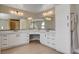 Elegant bathroom with dual sinks, large mirrors, white cabinetry, and hardwood floors at 7761 Cowboy Trl, Las Vegas, NV 89131